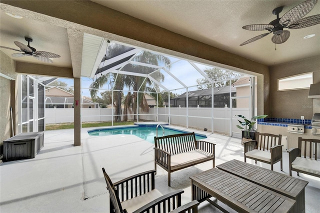 view of swimming pool featuring a patio, ceiling fan, and glass enclosure