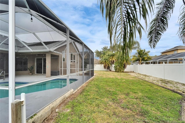 view of swimming pool featuring a patio, a yard, and glass enclosure