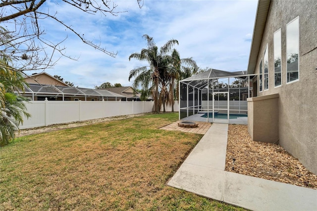 view of yard featuring a fenced in pool, a fire pit, a patio area, and glass enclosure