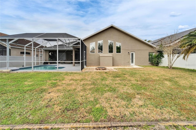 back of house featuring a fenced in pool, a fire pit, glass enclosure, and a lawn