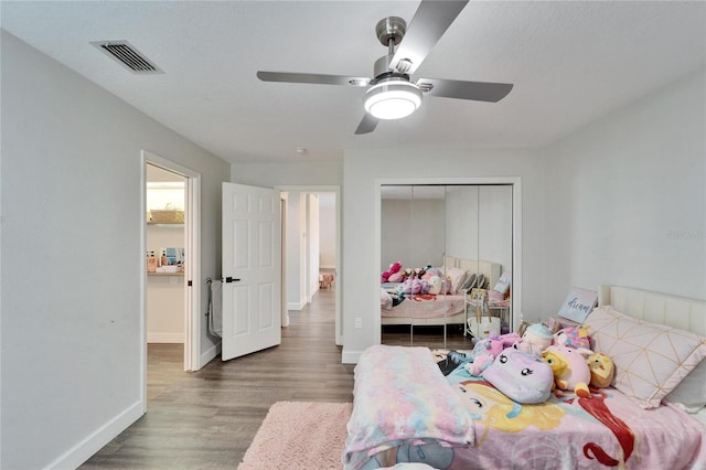 bedroom with ceiling fan, a textured ceiling, dark hardwood / wood-style flooring, and a closet