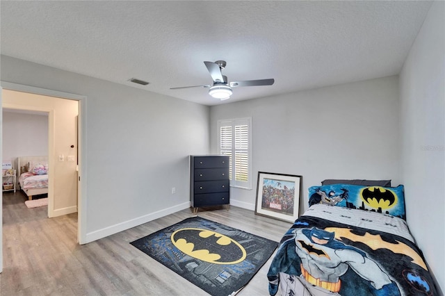 bedroom featuring wood-type flooring, ceiling fan, and a textured ceiling