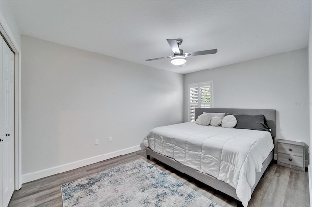 bedroom with hardwood / wood-style flooring, ceiling fan, and a closet