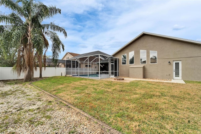 back of house featuring a fenced in pool, glass enclosure, and a lawn