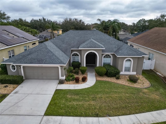 single story home with a garage and a front lawn