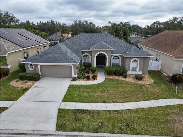 view of front of house featuring a shingled roof, a front lawn, and stucco siding