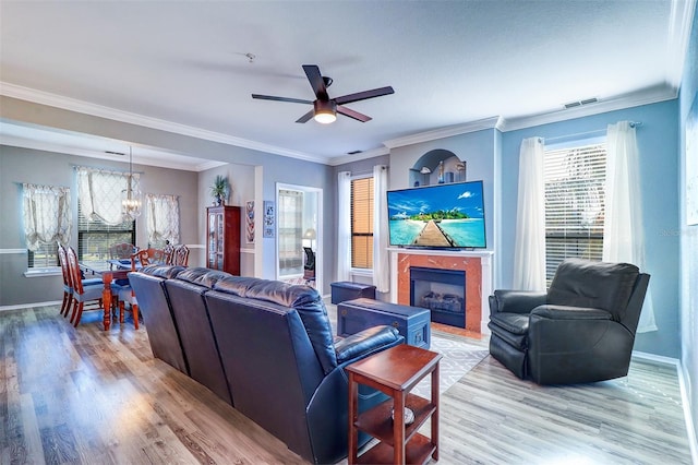 living room with ornamental molding, ceiling fan, and light hardwood / wood-style flooring