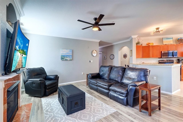 living room featuring ornamental molding, ceiling fan, and light wood-type flooring