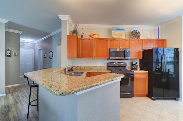 kitchen with sink, light stone counters, crown molding, kitchen peninsula, and black appliances