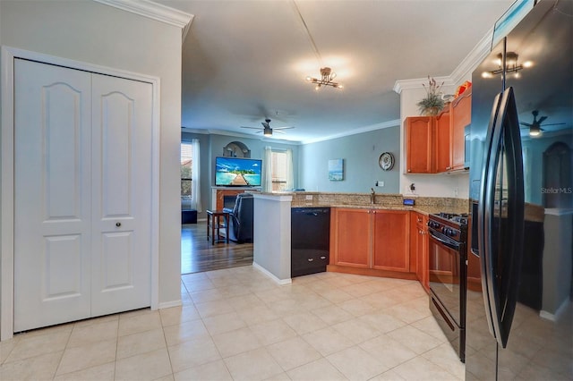 kitchen with sink, crown molding, light stone counters, black appliances, and kitchen peninsula