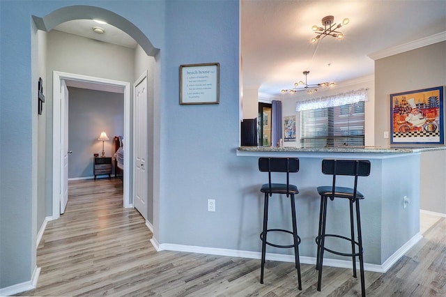 interior space featuring crown molding, a chandelier, and light wood-type flooring