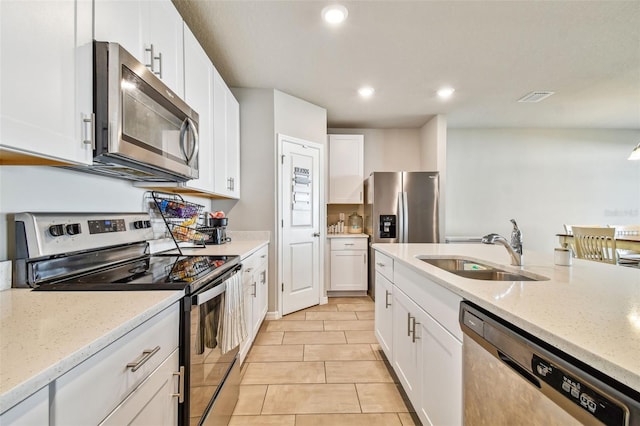 kitchen featuring sink, stainless steel appliances, white cabinets, and light stone countertops