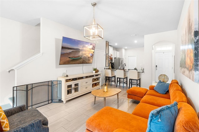 living room with a notable chandelier and light wood-type flooring