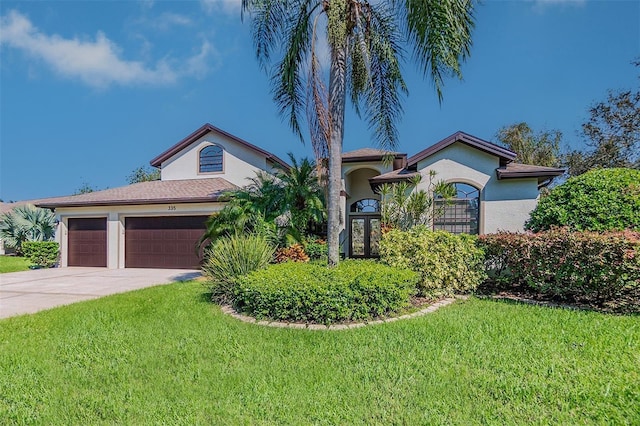 mediterranean / spanish-style house with french doors, a garage, and a front yard