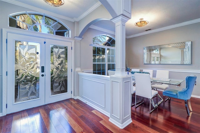 interior space featuring decorative columns, ornamental molding, dark hardwood / wood-style floors, and a wealth of natural light