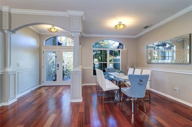 dining area featuring crown molding, dark hardwood / wood-style floors, and ornate columns