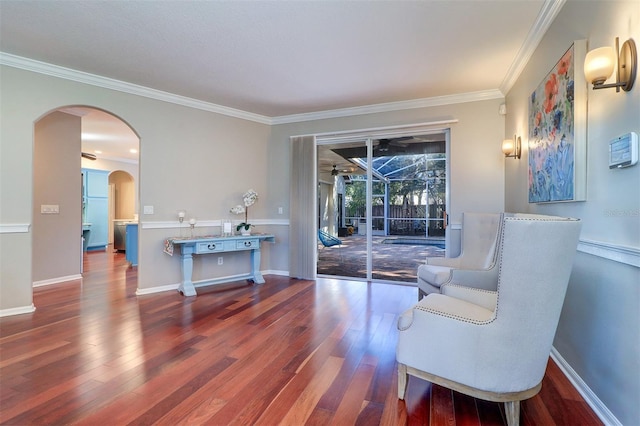 sitting room with hardwood / wood-style flooring, ceiling fan, and crown molding