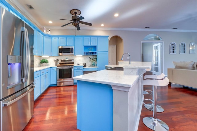 kitchen featuring stainless steel appliances, sink, a kitchen island with sink, and blue cabinets