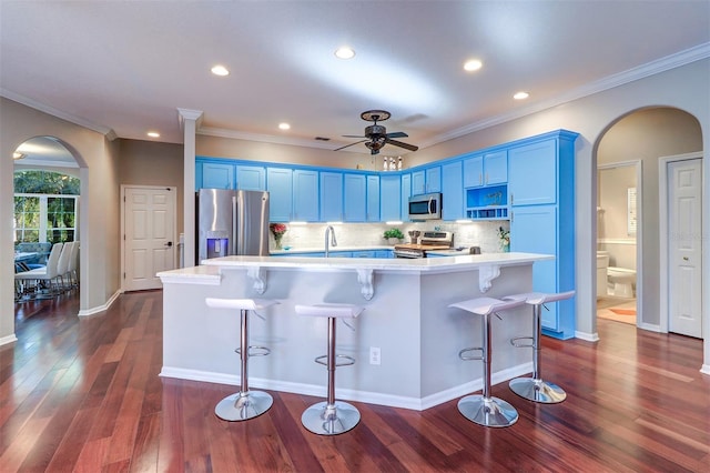 kitchen featuring blue cabinetry, stainless steel appliances, an island with sink, and a breakfast bar area