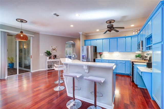 kitchen featuring appliances with stainless steel finishes, blue cabinetry, and a center island with sink