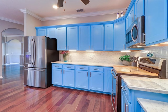 kitchen featuring crown molding, dark wood-type flooring, appliances with stainless steel finishes, backsplash, and blue cabinets