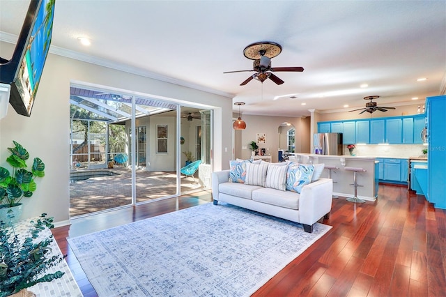 living room featuring ceiling fan, ornamental molding, and dark hardwood / wood-style floors