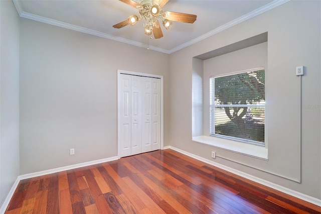 unfurnished bedroom with wood-type flooring, ceiling fan, crown molding, and a closet