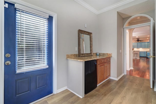 interior space with ornamental molding, a healthy amount of sunlight, and light wood-type flooring