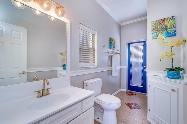 bathroom featuring tile patterned flooring, crown molding, vanity, and toilet