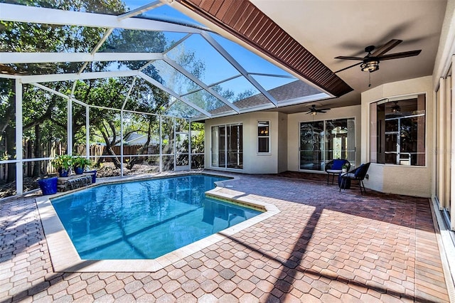 view of pool featuring pool water feature, a patio, ceiling fan, and glass enclosure