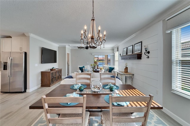 dining area with light hardwood / wood-style floors, crown molding, and a healthy amount of sunlight