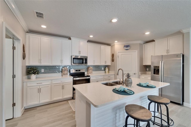 kitchen featuring appliances with stainless steel finishes, sink, a breakfast bar, and a center island with sink