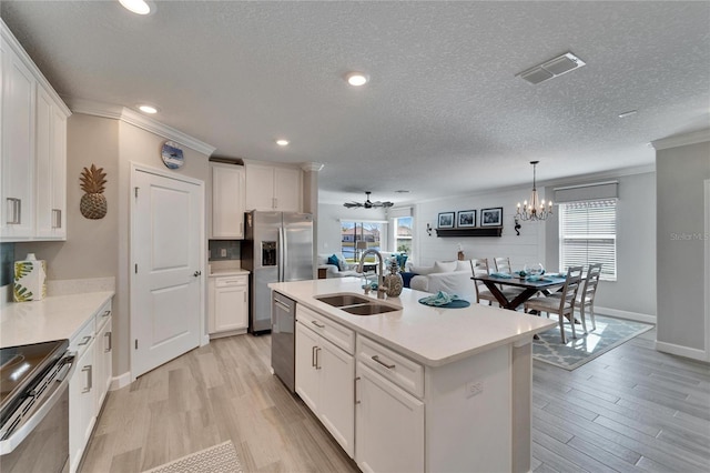 kitchen featuring an island with sink, white cabinetry, sink, and appliances with stainless steel finishes