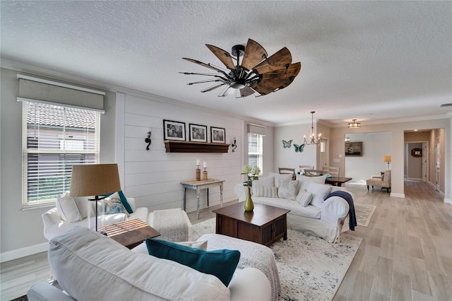 living room featuring a textured ceiling, crown molding, and light hardwood / wood-style flooring