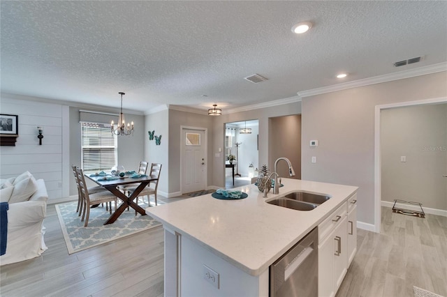 kitchen featuring white cabinets, sink, an island with sink, and dishwasher