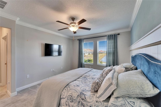 bedroom with ceiling fan, crown molding, a textured ceiling, and light colored carpet