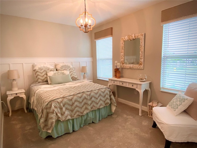 bedroom featuring multiple windows, carpet, and a notable chandelier