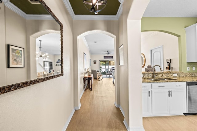 corridor featuring crown molding, a chandelier, sink, and light wood-type flooring