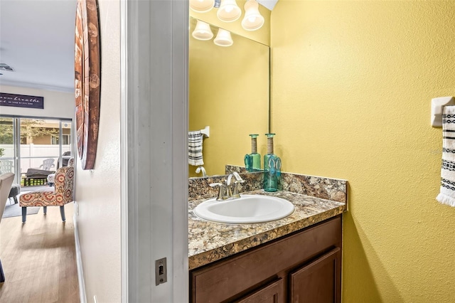 bathroom featuring vanity, hardwood / wood-style flooring, and ornamental molding