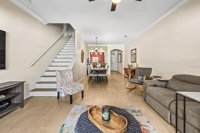 living room featuring crown molding, ceiling fan with notable chandelier, and light hardwood / wood-style flooring