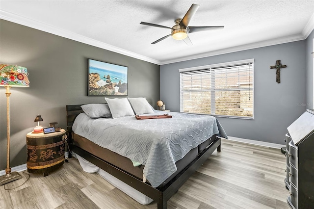 bedroom with ornamental molding, ceiling fan, a textured ceiling, and light hardwood / wood-style flooring