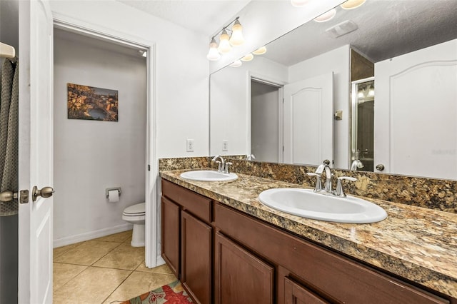 bathroom featuring vanity, tile patterned floors, a textured ceiling, and toilet