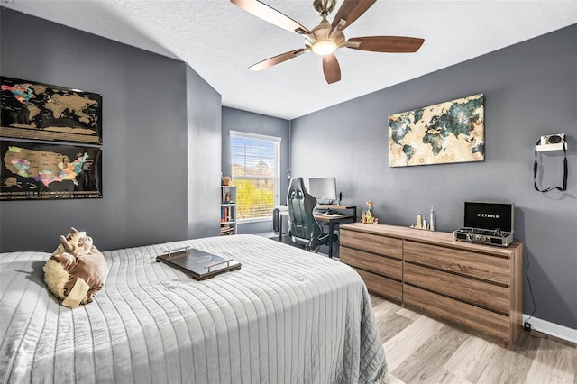 bedroom featuring ceiling fan, a textured ceiling, and light wood-type flooring