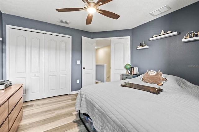 bedroom featuring ceiling fan, light hardwood / wood-style floors, and a closet