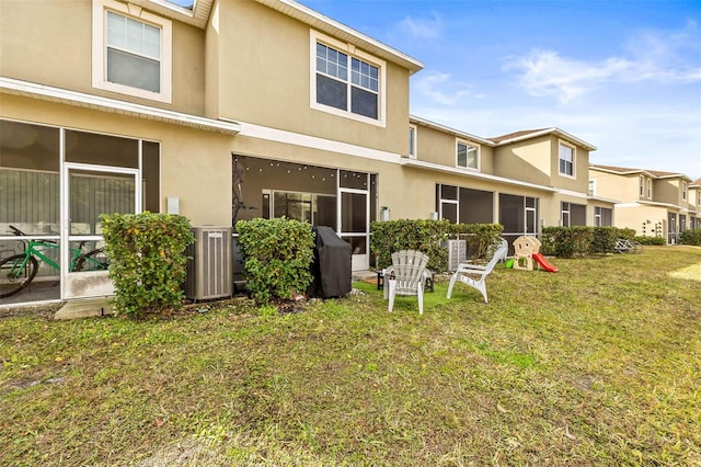 back of property featuring central AC unit and a yard