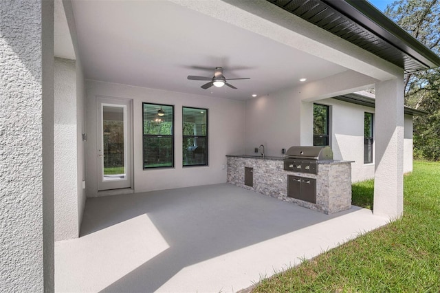 view of patio with a grill, sink, ceiling fan, and an outdoor kitchen