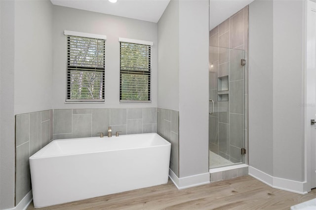 bathroom with wood-type flooring and separate shower and tub