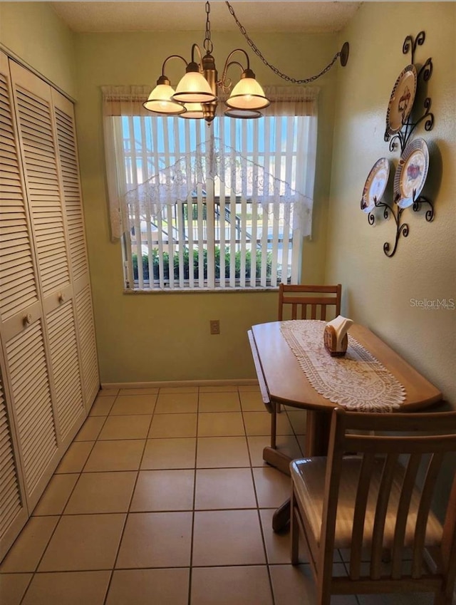 dining area featuring light tile patterned flooring and a chandelier