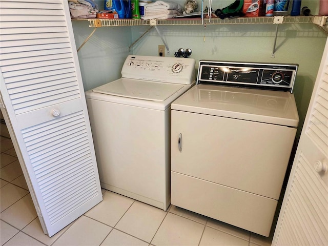 washroom with separate washer and dryer and light tile patterned floors