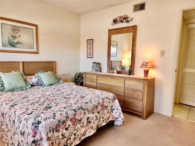 bedroom with light colored carpet and a textured ceiling